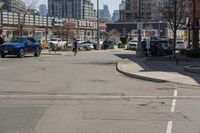 a woman riding her bike down the street between parked cars and a few other cars