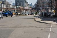 a woman riding her bike down the street between parked cars and a few other cars