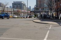 a woman riding her bike down the street between parked cars and a few other cars