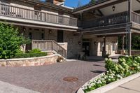 a front entrance to a brown brick building with a porch and steps leading up to it