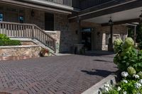 a front entrance to a brown brick building with a porch and steps leading up to it