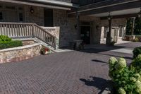 a front entrance to a brown brick building with a porch and steps leading up to it