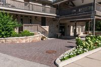 a front entrance to a brown brick building with a porch and steps leading up to it