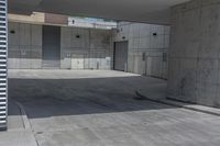 an empty cement parking garage with no doors and no sign on it in front of the building