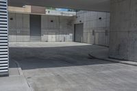 an empty cement parking garage with no doors and no sign on it in front of the building