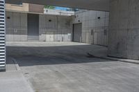 an empty cement parking garage with no doors and no sign on it in front of the building