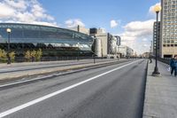 two roads that pass near a bus station on the street outside of a building with large glass structure