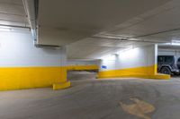 a car sits in an empty parking garage near yellow lines and yellow paint on the floors