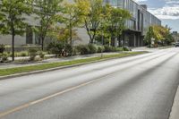 the roadway in front of the building is empty with grass on both sides of the road