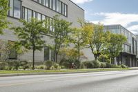 the roadway in front of the building is empty with grass on both sides of the road