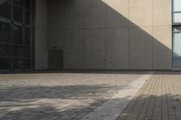 a man rides his skateboard on a city sidewalk near a building under an open sky