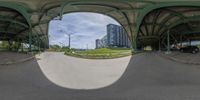 a reflection of a building on the outside of a skateboard ramp in an urban setting