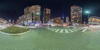 an intersection of two roads and buildings, taken with fish - eye lens point of view