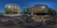 an urban looking picture of two buildings in the distance, as seen from below a spherical fish eye lens