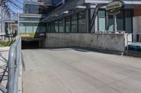 the entrance to a parking garage next to two empty benches and a building that says, no parking