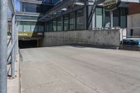 the entrance to a parking garage next to two empty benches and a building that says, no parking