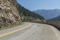 the view from an angle of a road near a mountain range is pictured on a clear day