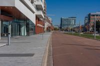 a street view with empty brick sidewalk and buildings behind it on either side of the street