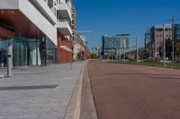 a street view with empty brick sidewalk and buildings behind it on either side of the street