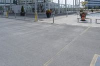 an open air parking area in the city and next to it is a dock area with benches and a large building