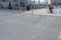 an open air parking area in the city and next to it is a dock area with benches and a large building