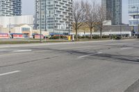 a sign post sits on the edge of an empty street with several buildings in the background