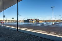 a view of a parking lot from outside a building on a sunny day the picture is taken from under