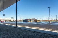 a view of a parking lot from outside a building on a sunny day the picture is taken from under