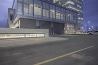 the parking lot in front of a glass building is empty and empty of cars parked outside