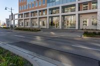 an empty street in front of some modern buildings in a city area of the sun