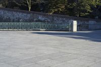 a skateboarder rides down the concrete path at a skate park while others watch