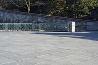 a skateboarder rides down the concrete path at a skate park while others watch