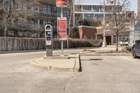 a red traffic meter sits at the corner in an urban setting near buildings and trees