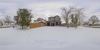 a house sits on a snow bank in the yard, a sign is in the ground