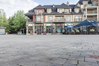 an old - fashioned square building with outdoor seating on it, and tables set up in the middle of it