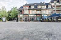 an old - fashioned square building with outdoor seating on it, and tables set up in the middle of it