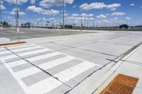 empty parking lot with a crosswalk and blue sky in the background with clouds on top