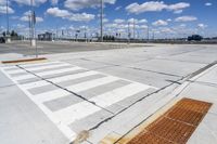 empty parking lot with a crosswalk and blue sky in the background with clouds on top