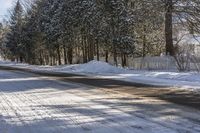 a snow covered street with a snowy fence in the distance and snow covered road leading the street