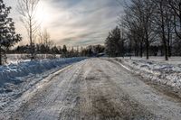 an empty snowy street is shown on a sunny day the road is empty and covered in snow