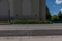 a bricked median along a street in front of an empty building and two trees