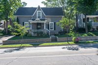 a bicycle is parked along a curb in front of a home, with the bicycle leaning on the curb