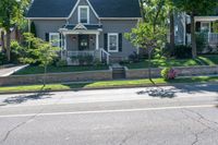 a bicycle is parked along a curb in front of a home, with the bicycle leaning on the curb