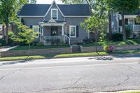 a bicycle is parked along a curb in front of a home, with the bicycle leaning on the curb