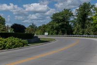 an empty asphalt road with trees in the distance, with no cars at the end