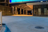 the view from the parking meter of a large building at night time, showing the entrance to a hotel