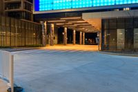 the view from the parking meter of a large building at night time, showing the entrance to a hotel