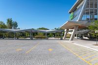 an empty parking lot with buildings in the background and blue skies above it in a sunny day