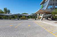 an empty parking lot with buildings in the background and blue skies above it in a sunny day