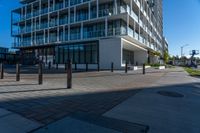 an empty road with concrete poles on both sides of it and buildings in the background